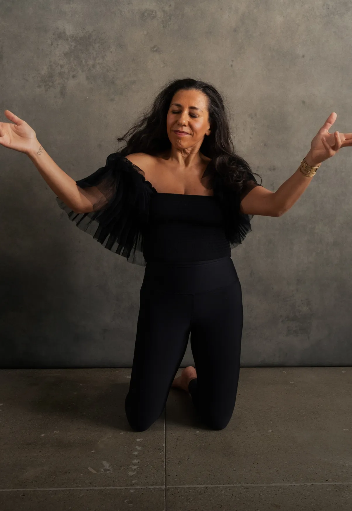 Person standing upright with eyes closed, arms slightly raised